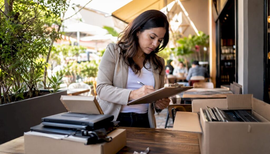 Woman coordinating electronics returns at warehouse desk