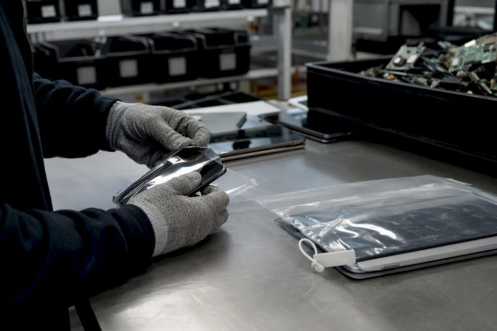 Gloved hands tagging e-waste with numbered seals