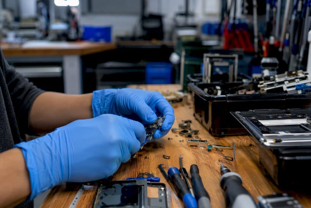 Hands sorting electronic components at recycling facility